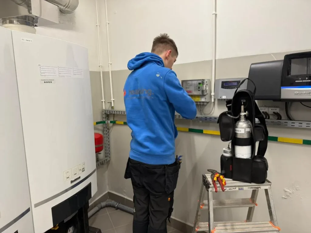 Technik podczas prac serwisowych systemu detekcji gazu w kotłowni w Gliwicach. Serwis systemu detekcji gazu w kotłowni szkoły w Gliwicach.